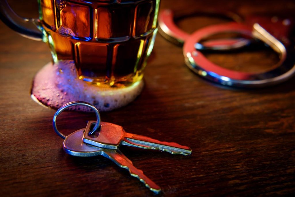 keys sitting next to alcoholic beverage